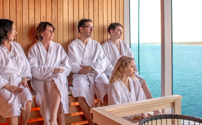 En grupp sitter i bastun p� Birka och kikar ut i sk�rg�rden